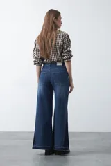 Jean de calce ultra wide confeccionado en denim de algodón color negro. Presenta una silueta amplia desde la cadera y un panel lateral en contraste que estiliza la pierna.