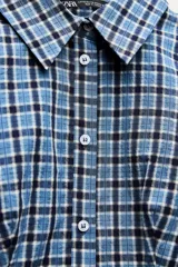 Camisa entallada de cuello solapa y manga larga con estampado de cuadros azules y negros.