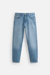 Pantalón de jean celeste de corte slim fit y tapered, con cinco bolsillos, efecto lavado y cierre frontal con cremallera y botón.