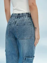 Pantalón de jean gris claro con efecto lavado, corte recto, tiro alto, bolsillos laterales y tobillos ajustados con elástico.