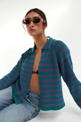 Cardigan tejido de punto a rayas horizontales verdes y violetas, con cuello polo y cierre frontal con botones.