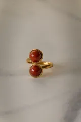 Anillo dorado ajustable de acero quirúrgico hipoalergénico con dos piedras redondas de color violeta.