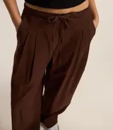 Pantalón wide leg color marrón chocolate, de corte sastrero con cintura elástica y lazo ajustable.