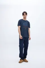 Remera negra de algodón con estampa central con la frase "Life Rhythm Punches Awakes" y pequeño logo en la espalda.