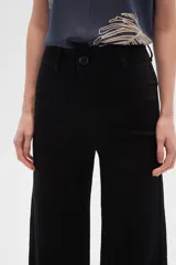 Pantalón de jean color beige, de corte flare y tiro alto, con terminación desflecada.