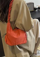 Cartera bandolera verde militar de nylon con textura sutil y manija fruncida.