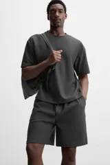 Bermuda negra de corte relaxed fit, con cintura elástica ajustable con cordón, bolsillos frontales y bolsillo trasero de parche.
