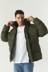 Campera puffer negra de nylon con cuello alto y capucha ajustable. Tiene bolsillos laterales y frontales con cierre.