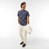 Camiseta azul marino de manga corta con estampado de palmeras y paisajes playeros en blanco.