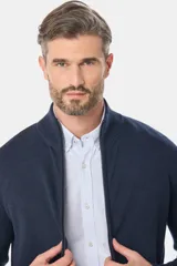 Campera tejida de algodón color azul con cierre frontal y cuello alto. Corte clásico.