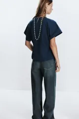 Camiseta color crudo de algodón con cuello redondo, manga corta caída y cintura ajustable con cordón.
