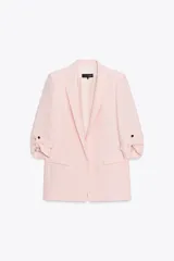 Blazer rosa pálido con cuello solapa y hombreras. Manga tres cuartos con vuelta y trabilla con botón dorado. Bolsillos delanteros con solapa.