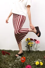 Minifalda de microtul con estampado a rayas verticales en tonos rosado y borgoña, con cordones laterales para fruncir.