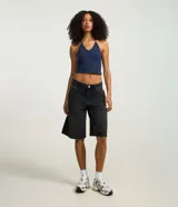 Blusa cropped de frente única color crema, confeccionada en algodón con elastano, con escote en V y lazo en el cuello.