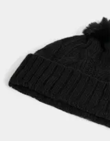 Gorro de lana tejido trenzado color negro, con pompón de piel sintética en la parte superior.