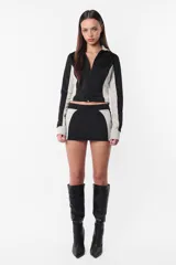 Minifalda negra de tiro bajo con recortes laterales en gris y logo estampado en la parte trasera.
