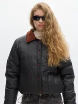 Campera verde con cuello beige de pana, largo a la cadera, con elástico inferior para ceñir a gusto. Cierre por botones a presión, bolsillos frontales y forro de cuerpo estampado de algodón.