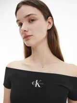 Remera Calvin Klein Essentials de corte slim, color negro, con cuello de hombros descubiertos, mangas cortas y logo estampado en el pecho.