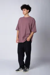 Remera verde militar de corte oversize, confeccionada en algodón 100% con cuello redondo y manga corta. Presenta un pequeño logo estampado en la parte superior de la espalda.