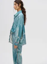 Camisa oversize celeste con estampado tie-dye, bolsillo en el pecho con bordado y terminaciones con ribete en contraste.