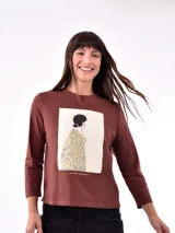 Remera blanca de manga larga con estampa rectangular dorada con diseño animal print y texto 'Fearless, fierce & fabulous'.