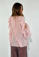 Camisa color rosa pálido con escote en V y volados en el frente y las mangas. Cierre con botones.
