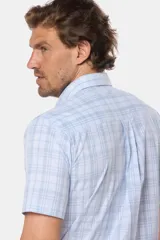 Camisa de manga corta con botones, color celeste con estampado a cuadros blancos. Hecha en Uruguay.