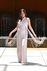 Mono largo color celeste, con escote halter cruzado, corte ajustado en la cintura y detalle de flecos largos en los laterales.