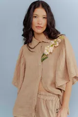 Camisa blanca de lino con cuello clásico y mangas cortas acampanadas.