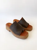 Sandalias de cuero color chocolate, con tira ancha sobre los dedos y suela de goma con plataforma.