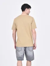 Remera negra de mangas cortas con estampado de palmeras y texto en color naranja.