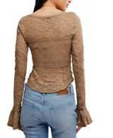 Blusa de encaje color borgoña, de mangas largas y corte ajustado.