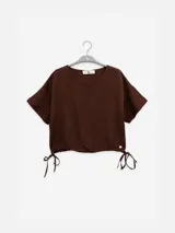 Top corto color crudo de lino tencel, con mangas cortas y lazo ajustable en el ruedo.