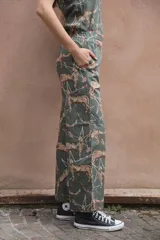 Pantalón de lino y algodón color verde con estampado de leopardos y estrellas blancas, corte palazzo con elástico en la cintura y bolsillos laterales.