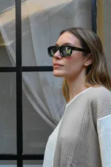 Lentes de sol negros con marco cuadrado y patillas gruesas.