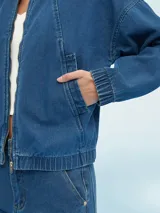 Campera de jean azul con cierre frontal, bolsillos laterales y puños elastizados.