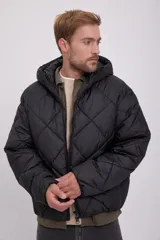Campera puffer negra con capucha ajustable con cordón, cierre con cremallera, bolsillos frontales y tejido acolchado resistente al viento.