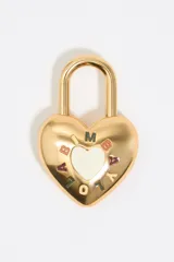 Llavero de metal dorado con forma de corazón, con aro superior para colgar. El cuerpo del corazón tiene un centro blanco con la letra 'M' en la parte superior y letras de colores alrededor que forman una palabra o iniciales.