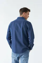 Camisa marrón de manga larga con bolsillo en el pecho y cierre con botones.