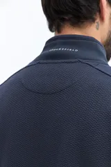 Campera de algodón con cierre frontal, cuello alto en color verde oliva y cuerpo texturado con patrón de espiga en tono marrón topo. Las mangas son lisas y del mismo tono que el cuerpo. Presenta un pequeño logo bordado en el pecho.