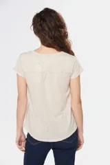 Remera color beige con escote redondo, manga corta, bolsillo en el pecho y cierre parcial con botones.