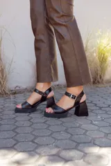 Sandalias negras de cuero con textura de cocodrilo, plataforma delantera y tacón geométrico.