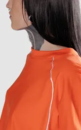 Remera corta naranja con mangas cortas abullonadas y ribete blanco en cuello, mangas y laterales.