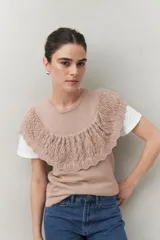 Chaleco color beige de tejido de punto con cuello redondo y volados de crochet en el frente y la espalda.