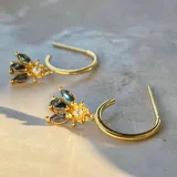 Aro de plata de ley 925 con acabado en oro de 18k y piedras de zirconia, diseño elegante y moderno.