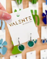 Aros colgantes con forma circular, color verde esmeralda, con borde de strass plateado. El aro es de acero.