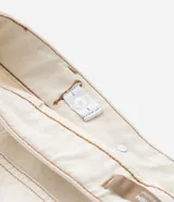 Short pollera de sarga color beige, con parte delantera cruzada, bolsillo con solapa delantero, bolsillos traseros y cintura con ajuste elástico interior.