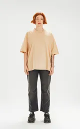 Remera color beige de corte crop y calce oversize, con hombros caídos y cuello redondo.