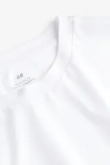 Remera blanca de algodón de manga larga con cuello redondo.