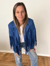 Campera de gamuza sintética color azul con flecos largos en mangas y espalda, corte recto con solapas clásicas.